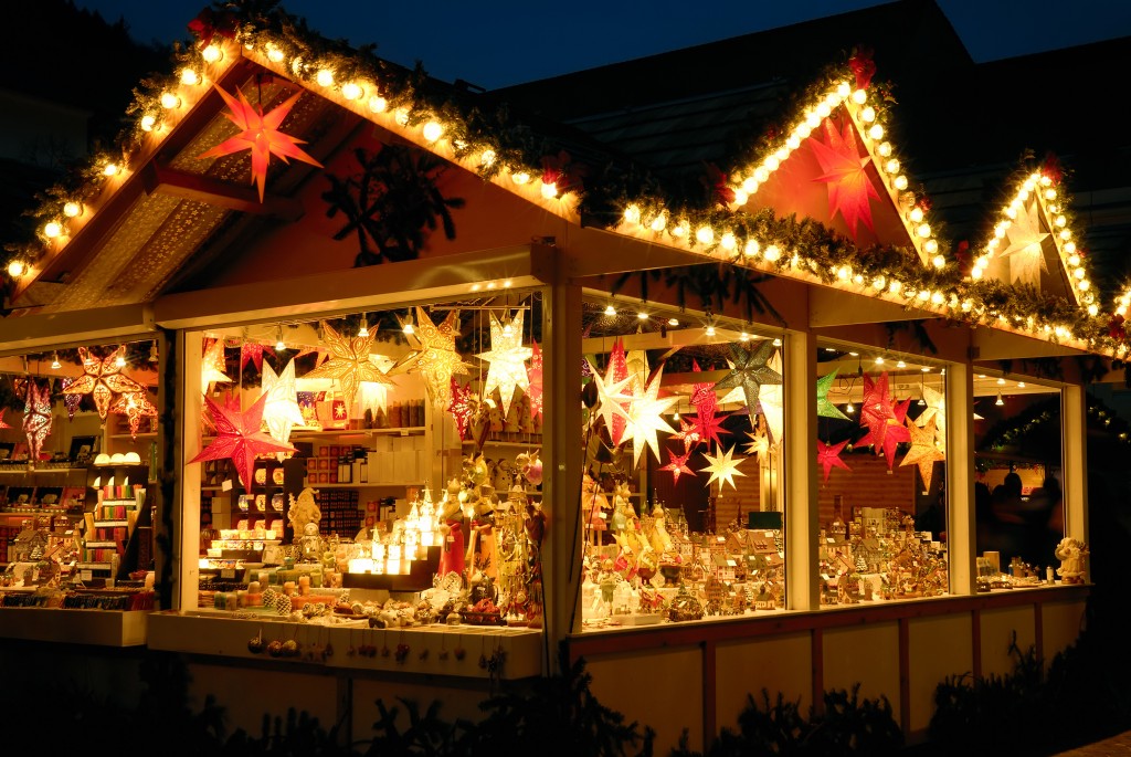 Bunt leuchtender Verkaufsstand am Weihnachtsmarkt mit vielen Dekowaren, keine Logos